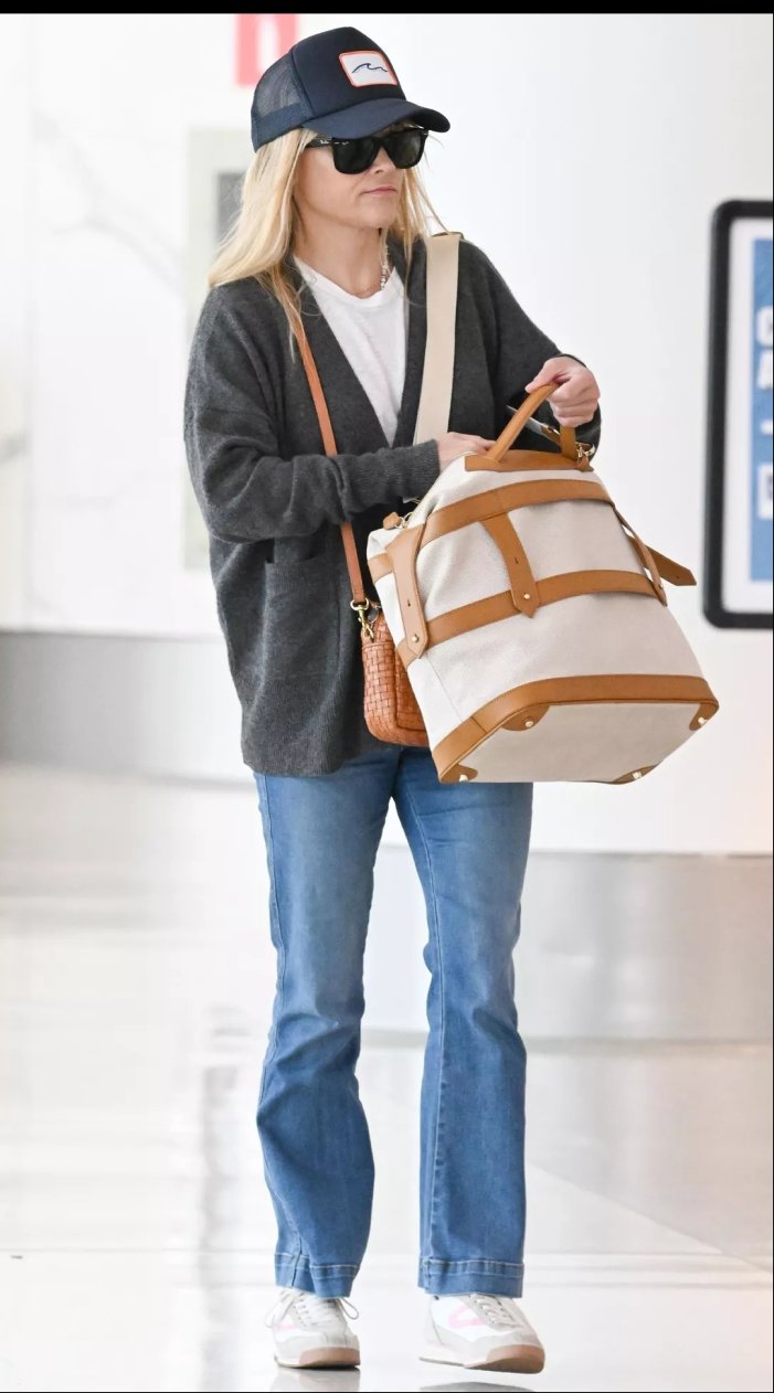 Reese Witherspoon at the airport carrying a cream Paravel weekender with cognac leather trim.