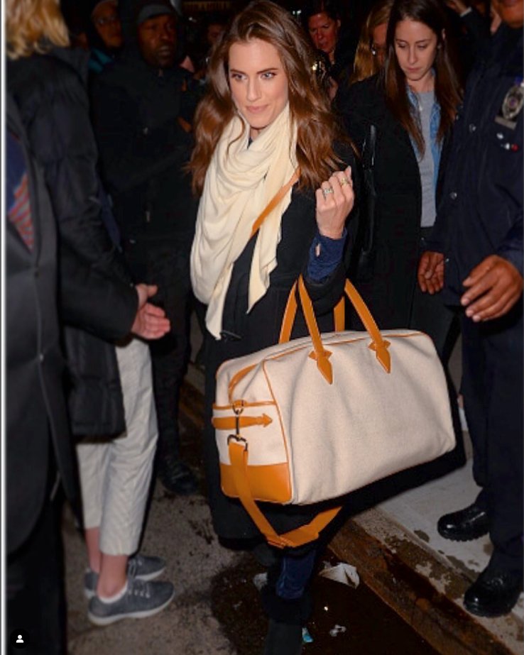 Allison Williams holding a cream Paravel weekender with tan trim outside an event.