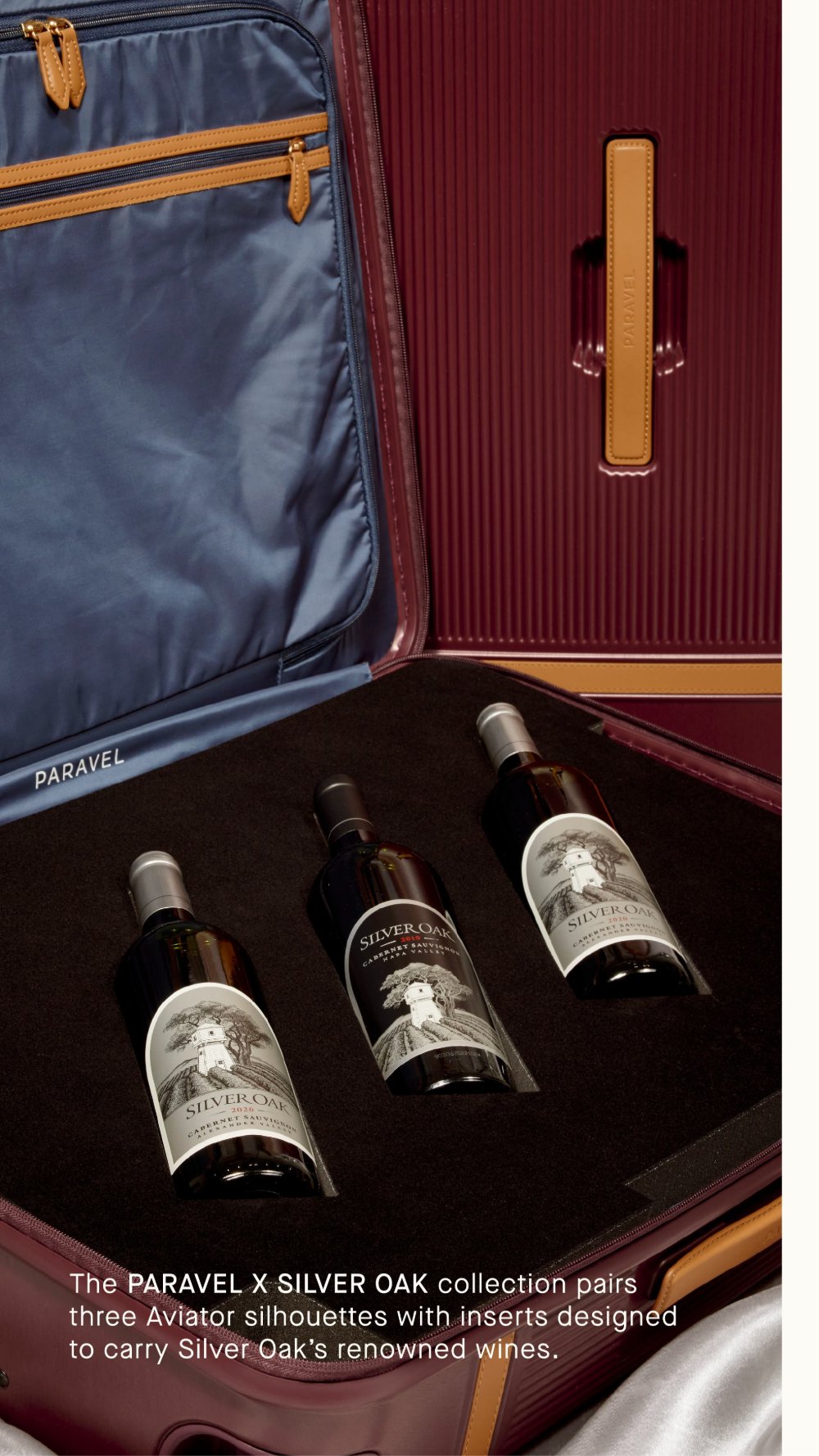 An open oxblood Paravel Aviator with a fitted insert cradling three bottles of Silver Oak Cabernet Sauvignon.