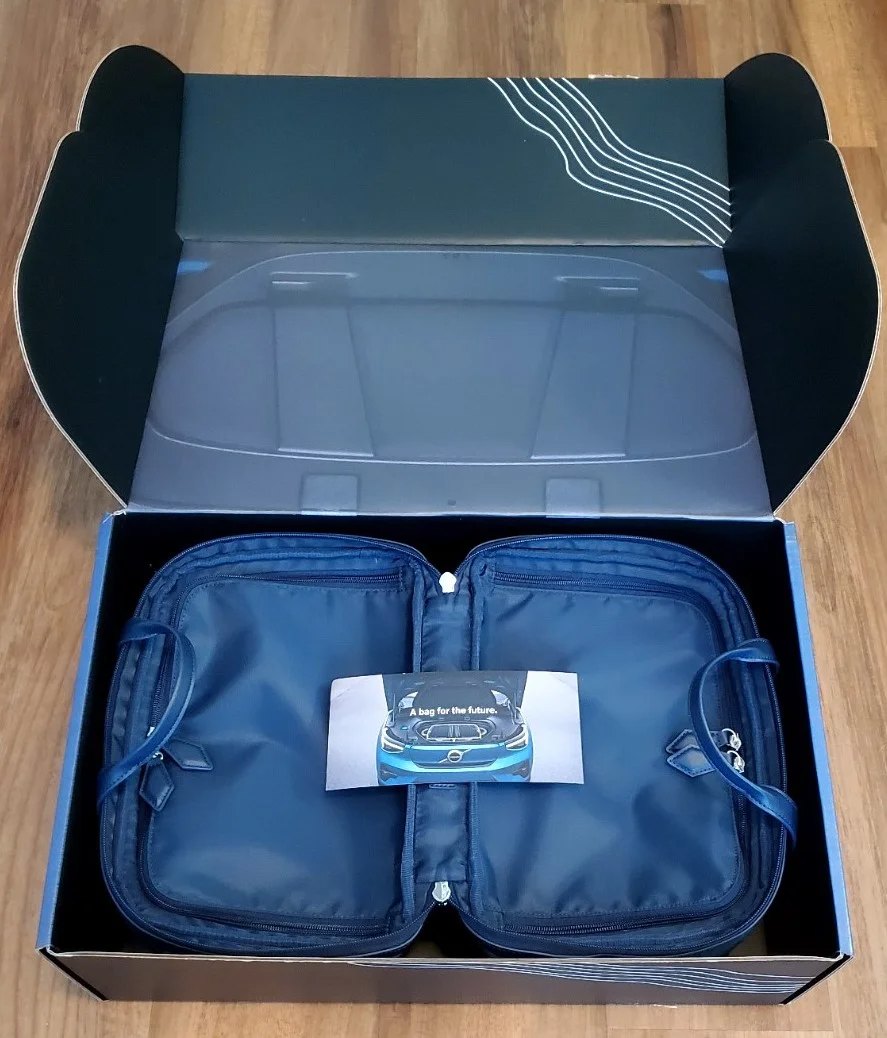 A Volvo-branded Paravel presentation box opened to reveal a navy zip travel organizer with a 'bag for the future' card.