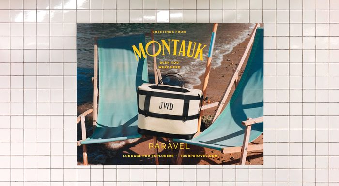 A 'Greetings from Montauk' PARAVEL poster on station tile, a monogrammed cooler bag set between two turquoise beach chairs.